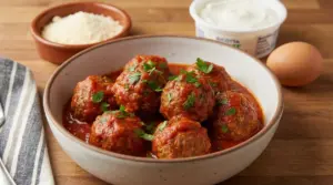 Polpette al sugo in ciotola di ceramica con ricotta, uovo e formaggio sullo sfondo