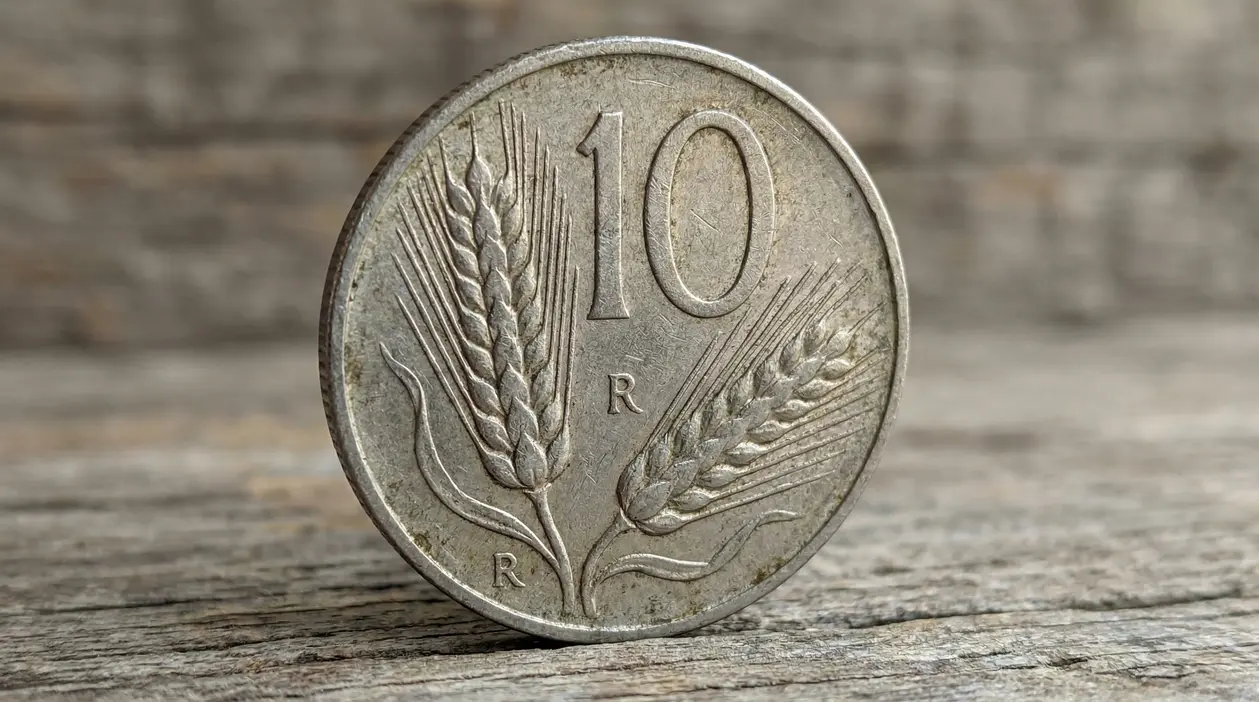 Moneta italiana da 10 lire Spiga del 1954 su sfondo in legno
